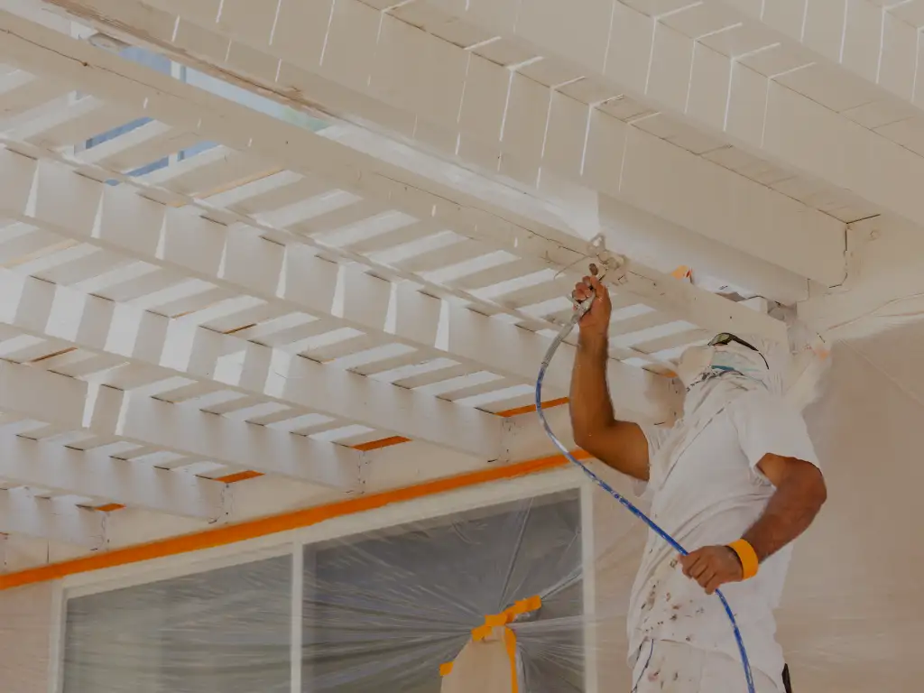 man wearing white painting a ceiling. Local House Painting contractor in Miami-Dade