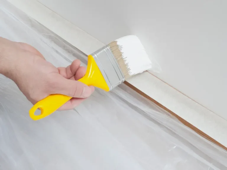 hand holding a yellow brushing paint- house painting services in miami dade